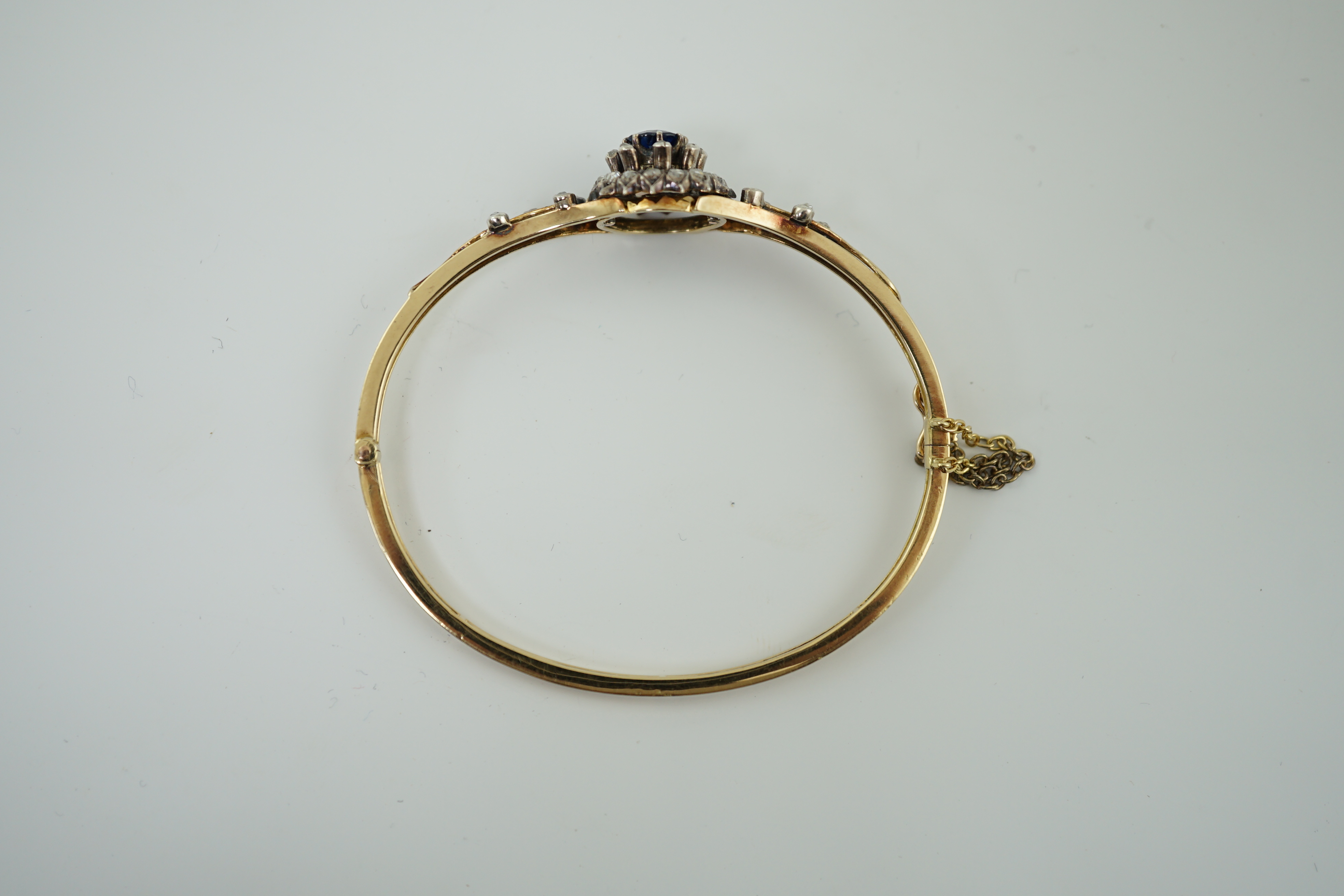 A Victorian gold, sapphire and diamond cluster set hinged bangle